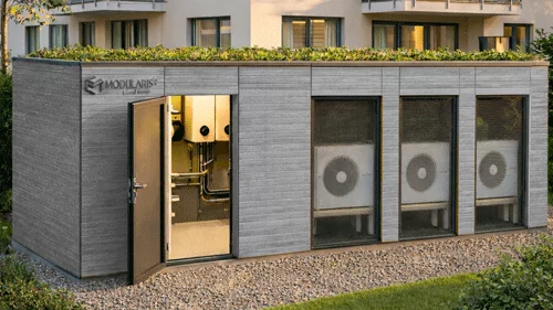 Modularis Energiezentrale in SISA Sonder mit Dichte vergraut als Außenfassade vor einem Mehrfamilienhaus